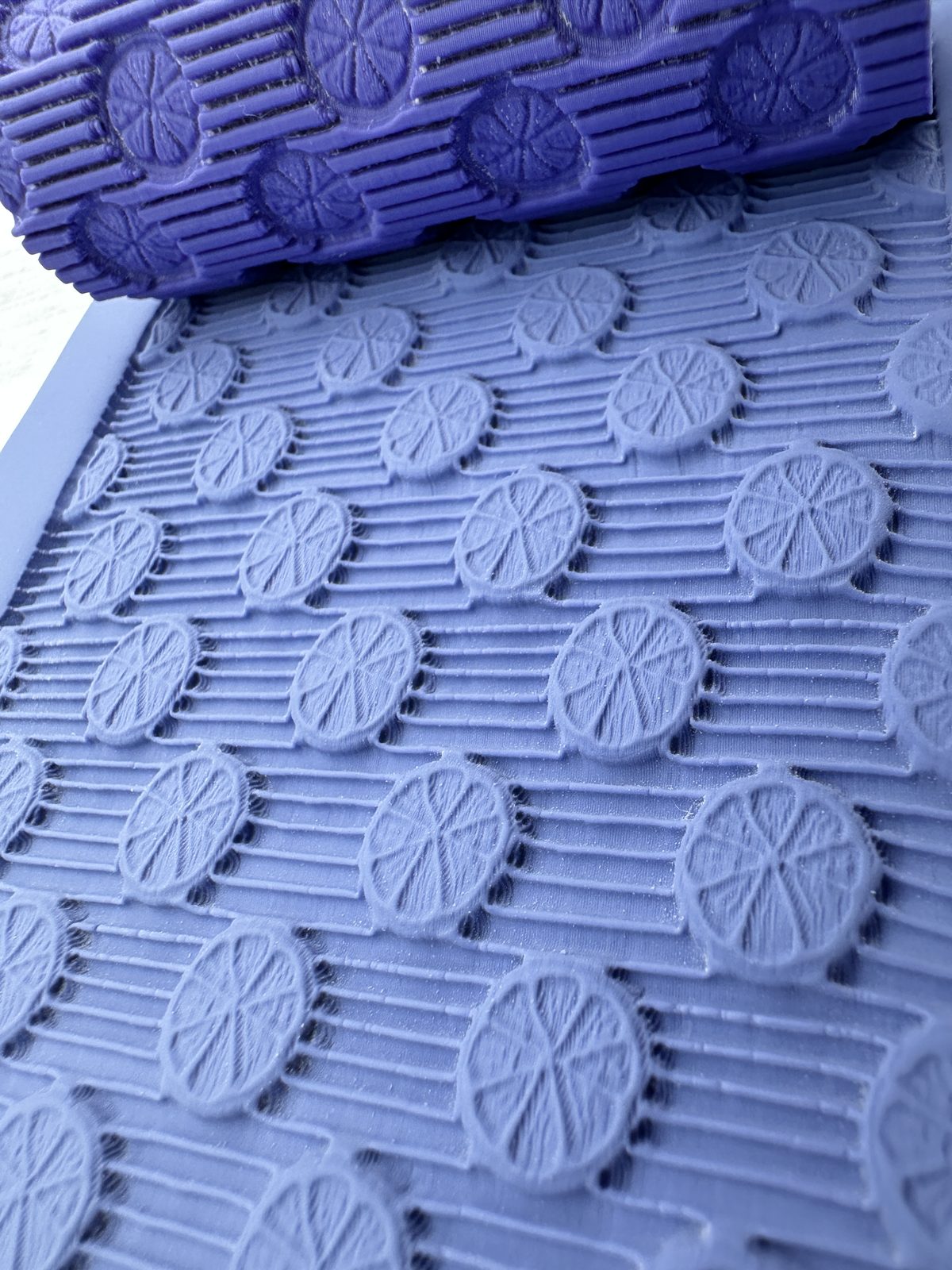 Citrus slice texture roller pressed into periwinkle polymer clay