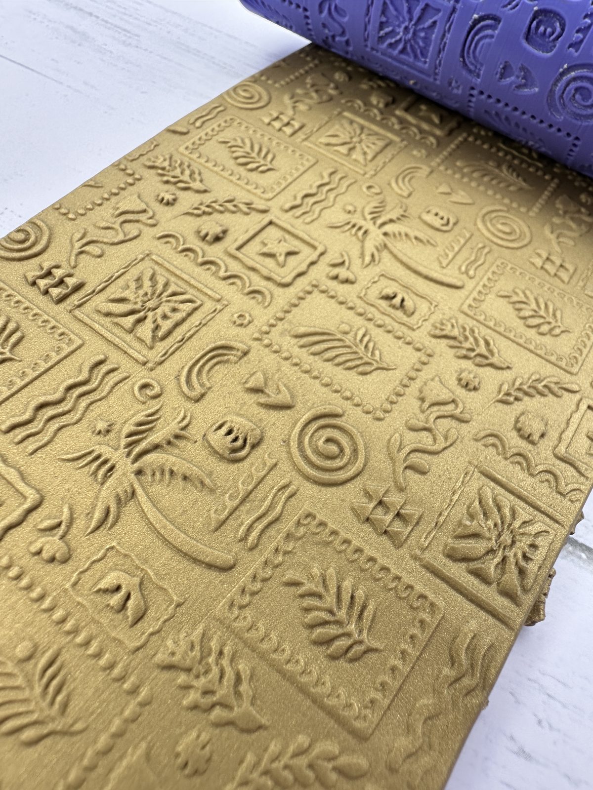 Tropical stamps texture roller pressed into gold polymer clay
